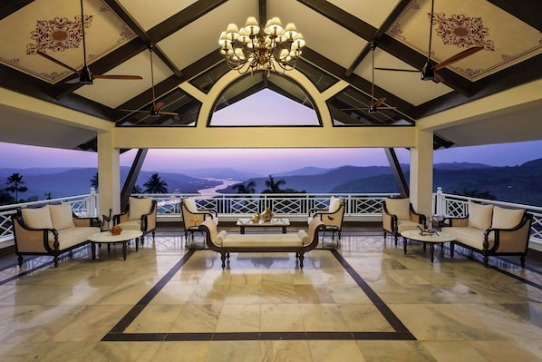Un amplio salón con techo alto, candelabros y vistas a la montaña.