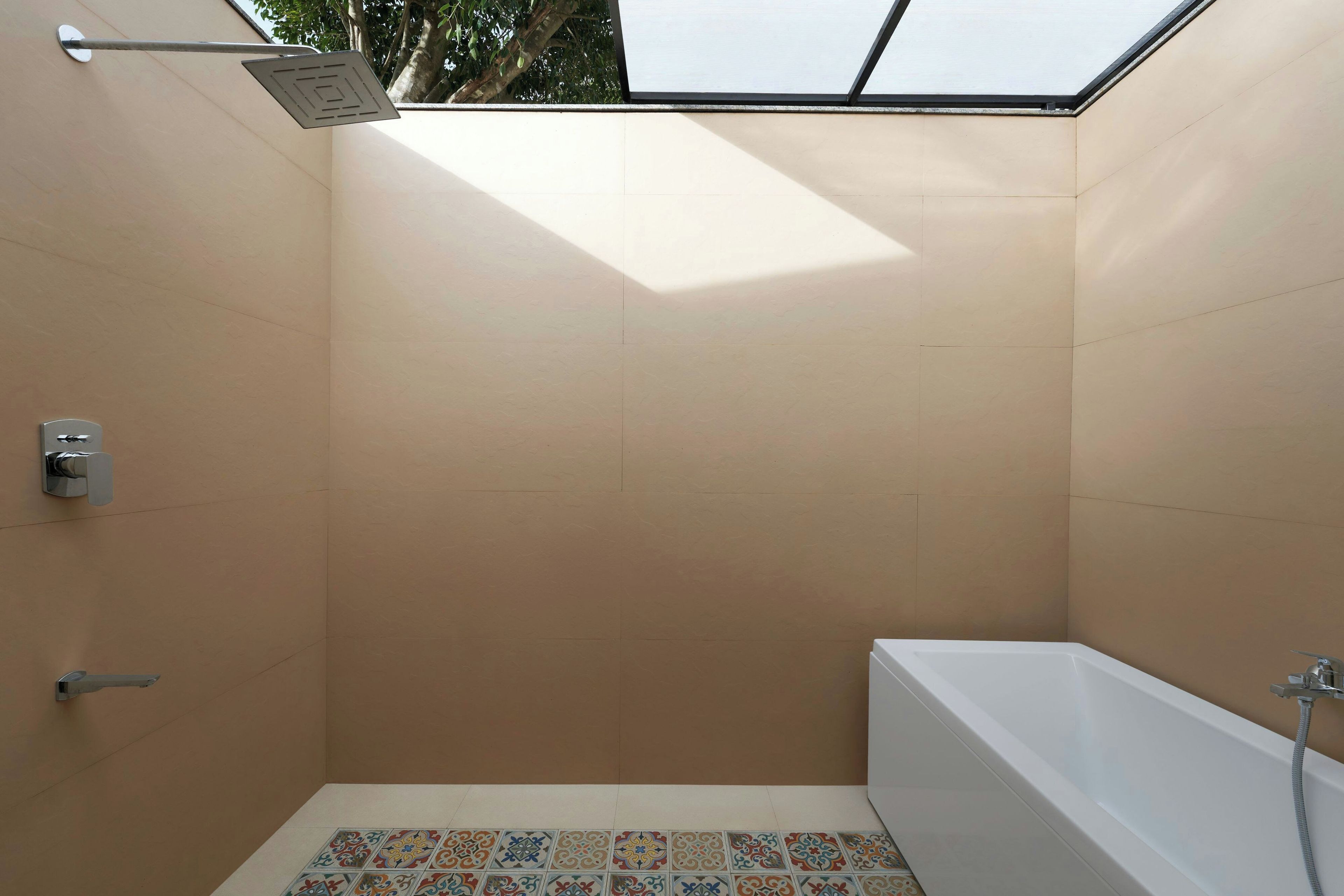 A modern bathroom with a skylight, a bathtub, and a shower.