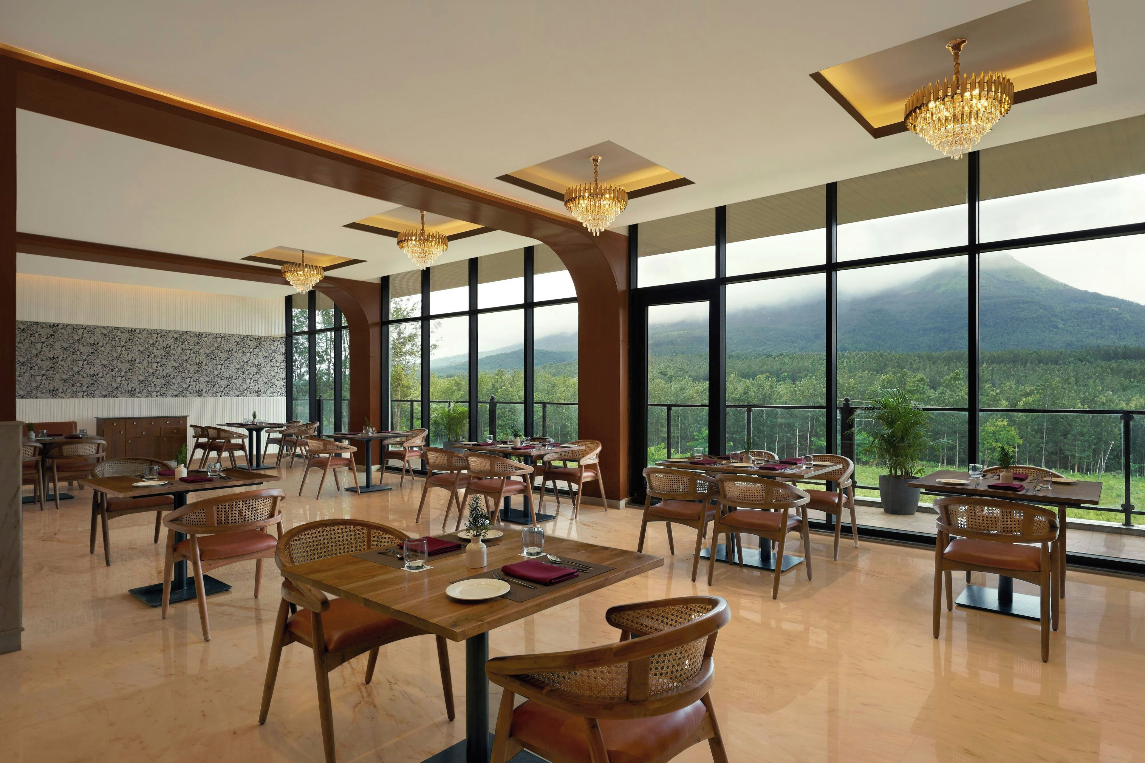 A spacious dining area with high ceilings, large windows, and a mountain view.