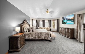 A bedroom with a large bed, a dresser, a nightstand, a ceiling fan, and a large window with curtains. - 5 bed / 4.5 bath, large entertaining luxury home w/reservoir access nearby (Pueblo)