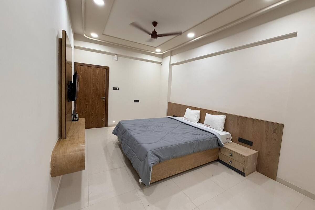 A modern bedroom with a bed, nightstand, and built-in wardrobe.