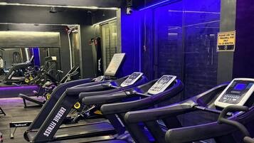 A gym with multiple treadmills, exercise equipment, and a sign indicating treadmill usage time.