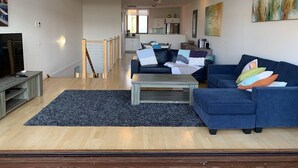 A living room with a sofa, coffee table, and a TV. - Villa #91 South Shores ~ The golden hour (Normanville)