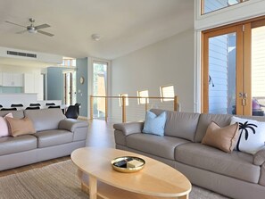 Ein modernes Wohnzimmer mit zwei Sofas, einem Couchtisch und einem Essbereich mit Stühlen.