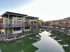 A waterfront property with multiple buildings, a dock, and a calm water body.