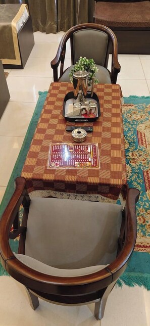 A dining table with a checkered tablecloth, a decorative centerpiece, and a menu. - Shakuatulm Pravas (Bhimtal)
