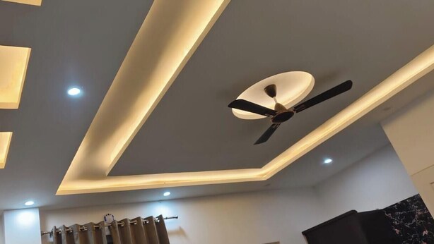 A ceiling with recessed lighting, a ceiling fan, and a modern design. - Shakuatulm Pravas (Bhimtal)