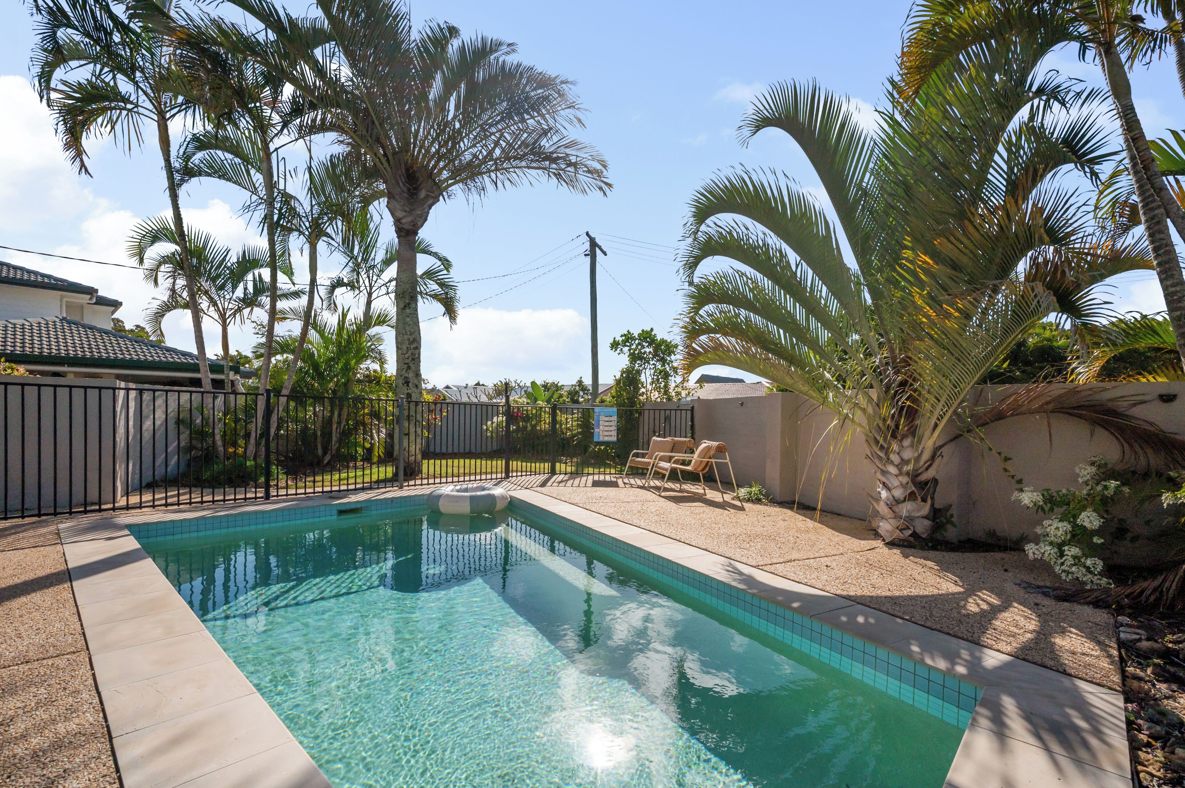 Sparkling in-ground pool with tropical palm views.