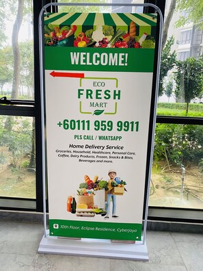 A signboard for Eco Fresh Mart with a contact number and services listed. - Modern 2BR Condo in Bukit Bintang with Pool, Gym, Netflix, Walk Everywhere (Kuala Lumpur)