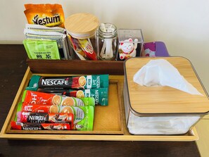 A drawer with various Nescafe coffee packets, a Nestum tea bag, a jar with a lid, and a Maneki-neko figurine. - Modern 2BR Condo in Bukit Bintang with Pool, Gym, Netflix, Walk Everywhere (Kuala Lumpur)