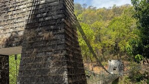 A stone structure with a bridge extending over a forested area. - Raiseraa Cottages (Lansdowne)