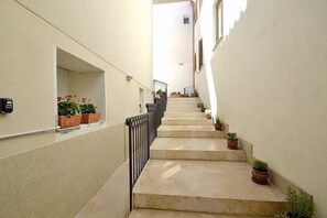 Eine enge Treppe mit bepflanzten Seitenteilen, die zu einer oberen Etage führt.
