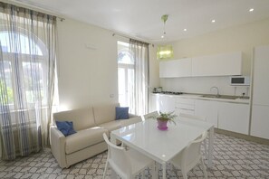 Eine moderne Küche mit weißen Schränken, einer Mikrowelle und einem Essbereich mit Tisch und Stühlen.