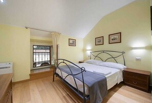 Ein Schlafzimmer mit Bett, Nachttisch und einem Fenster mit Aussicht.