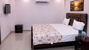 Un dormitorio con cama, mesita de noche, aire acondicionado de pared y un cuadro en la pared.