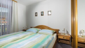 Une chambre à coucher avec un lit, des tables de chevet et un miroir.
