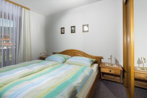 A bedroom with a bed, bedside tables, and a mirror. - Vacation apartment Watzmann, 25 sqm, 1-2 persons, 1 separate bedroom, balcony (Schönau am Königssee)