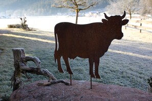A metal cow sculpture on a rock with a natural landscape in the background. - Vacation apartment Watzmann, 25 sqm, 1-2 persons, 1 separate bedroom, balcony (Schönau am Königssee)