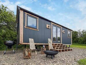 Et moderne hus med to etager, store vinduer og en træterrasse.