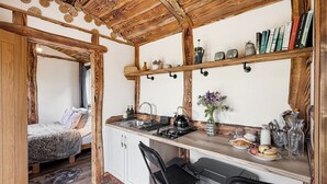 A compact kitchen with a wooden countertop, a gas stove, a sink, and a bar area with stools. - 1 bedroom accommodation in Corwen (Corwen)