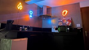 Cozinha moderna com micro-ondas, geladeira e um pequeno espaço para refeições.