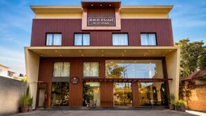Een hotel met een moderne gevel, grote ramen en een bord dat aangeeft dat het deel uitmaakt van de iO Hotels keten.