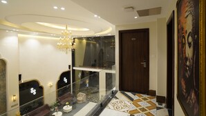 Een hotel lobby met een kroonluchter, een glazen balustrade, een houten deur en een vloer met een patroon.