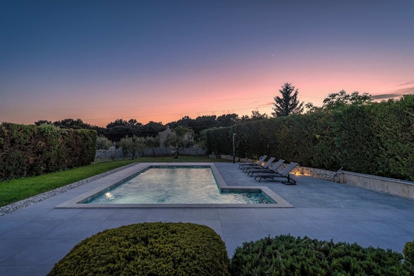 A rectangular swimming pool with a paved deck, surrounded by well-maintained hedges and trees. - Villa Casa Rita (100601-K1) - Porec (Porec)