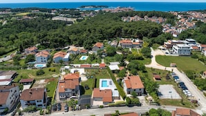 Vista aérea de una zona residencial con casas, piscina y carretera.