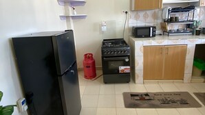 Una cucina attrezzata con frigorifero, fornello a gas, forno a microonde e pensili.