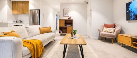 A modern living room with a sofa, coffee table, and a TV.