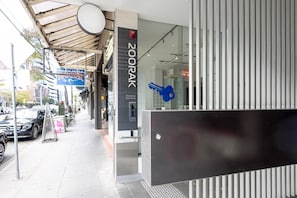 A modern building with a glass facade, a sign for '200RAK Residential Apartments,' and a blue key symbol indicating a keycard access point. - South Yarra Retreat, Morning Hot Air Balloon Views (South Yarra)