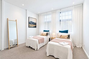 A hotel room with two beds, a large mirror, a painting, and a view of the outdoors. - The Hudson | 3BR Bright Courtenay Place Townhouse (Wellington)