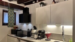 Cocina moderna con microondas integrado, cafetera y lavamanos.