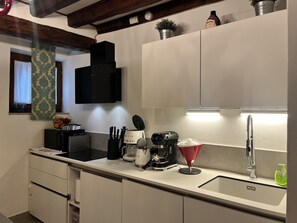 Eine moderne Küche mit Einbau-Mikrowelle, Kaffeemaschine und Spüle.
