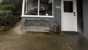 Uma casa de dois andares com varanda da frente, um banco e garagem.