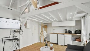 Eine moderne Küche mit weißen Schränken, einer Holz Arbeitsplatte und einer eingebauten Mikrowelle.