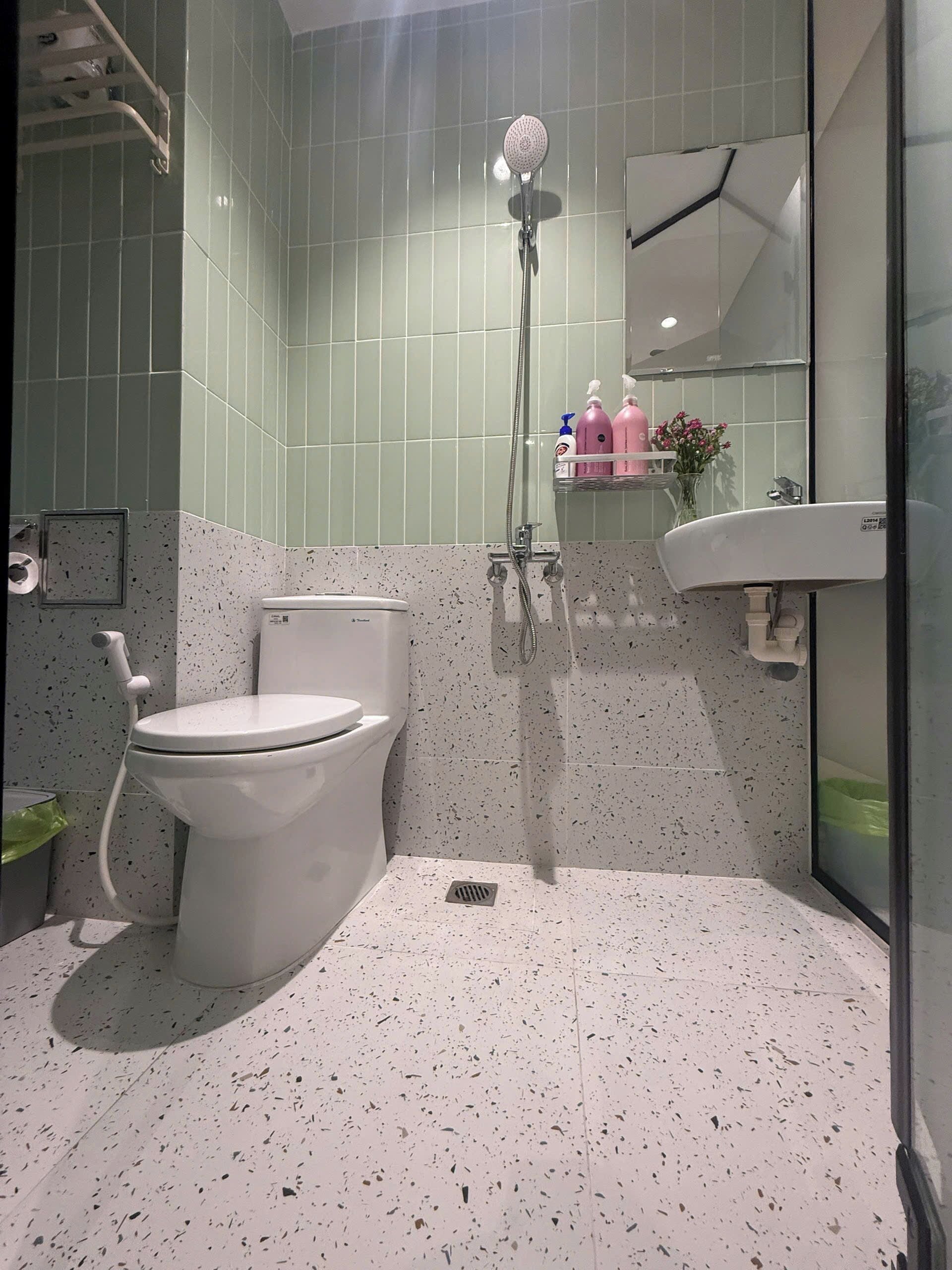 Une salle de bain avec des toilettes, une douche et un lavabo.