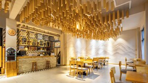 A restaurant with wooden furniture, a bar area, and a decorative ceiling. - Jianshanxi Designer Hotel (Ngawa Autonomous Prefecture)