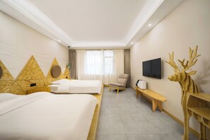 A hotel room with two beds, a chair, a bench, a TV, and a decorative deer head.