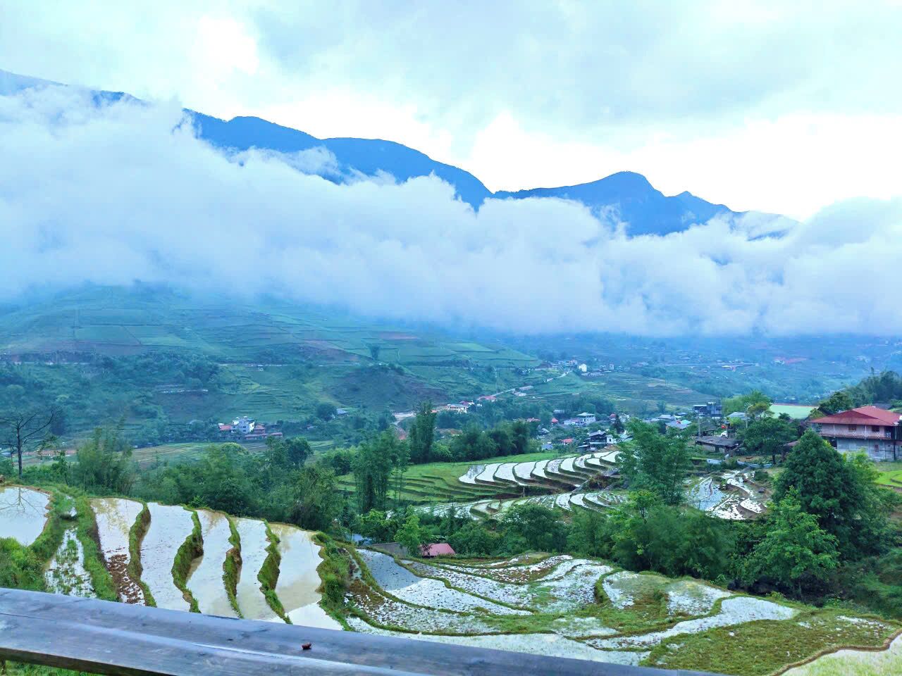 Terraced rice fields, a village, and mountains in the background.