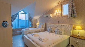 A bedroom with two beds, a window with curtains, a wall-mounted air conditioner, and bedside lamps. - Premium 4 bedroom villa in Oludeniz (Fethiye)