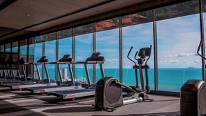 Ett gym med konditionsmaskiner och utsikt över havet.