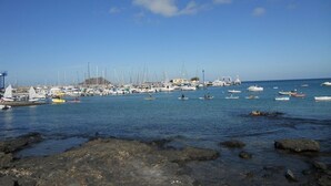 A marina with boats and yachts docked along the shore. - Lovely   Apt  Siesta (Corralejo)