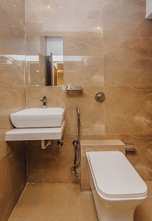 Un baño con lavamanos blanco, inodoro y ducha.