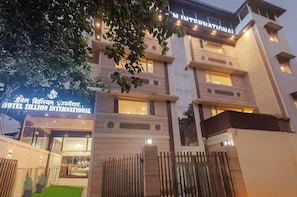 A hotel with a sign reading 'HOTEL ZILLION INTERNATIONAL' and a balcony with a view.