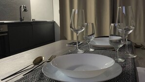 Ett matbord dukat med tallrikar, glas och bestick, och ett mönstrat bordsdukslag.
