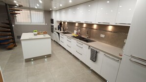 Een moderne keuken met witte kasten, een centraal eiland en een inbouwoven.