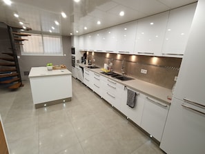 Una cocina moderna con gabinetes blancos, una isla central y un horno empotrado.
