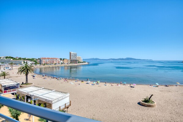 Ein Strand mit Restaurant, Hotel und Meerblick.